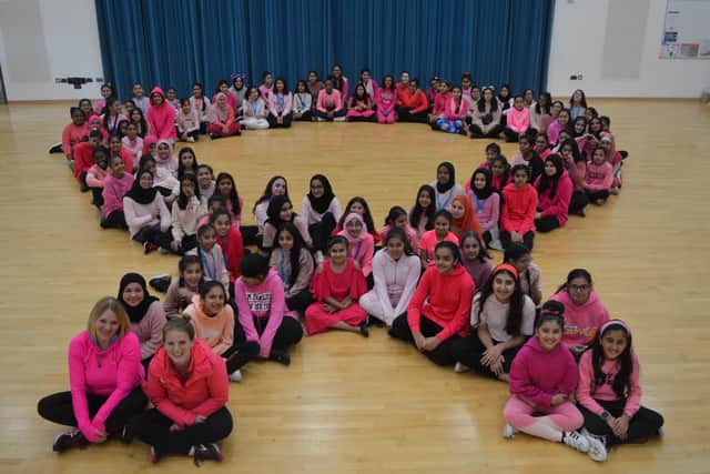 The pupils create the ‘pink ribbon’ - the international symbol of breast cancer awareness.