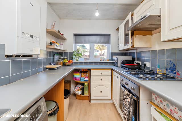 The fitted kitchen provides practical workspace and storage, forming part of a ground-floor layout with several distinct living areas.