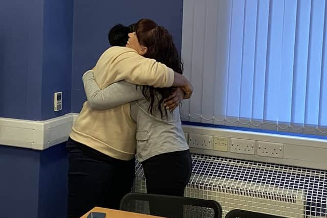 A Total Wellbeing Luton staff member and attendee share a heartfelt embrace during the World Mental Health Day 2025 event