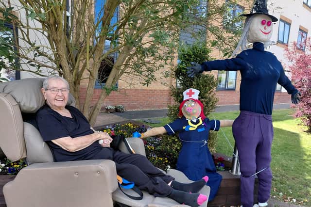 Resident John Winch with the scarecrow display