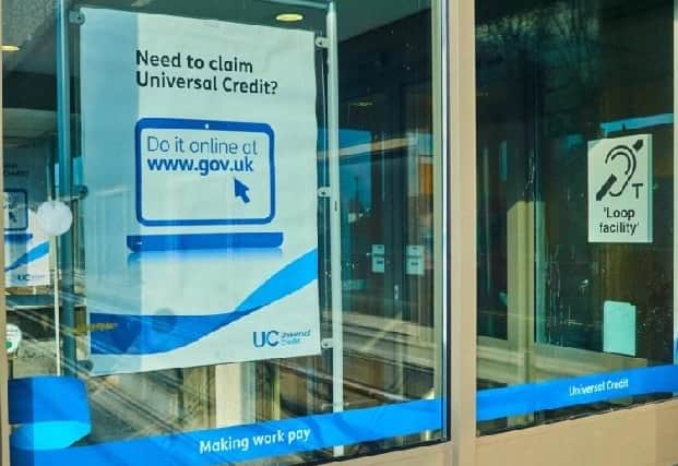 Job Centre window with a sign telling people to apply for Universal Credit on-line