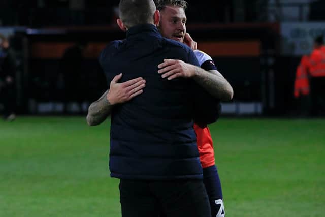 George Moncur gets a hug from Luton boss Graeme Jones