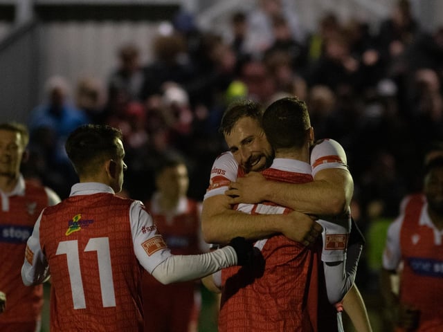 Jake Day hugs Kieran Glynn after he set up the forward to score the late winner in the cup derby against Whitby Town