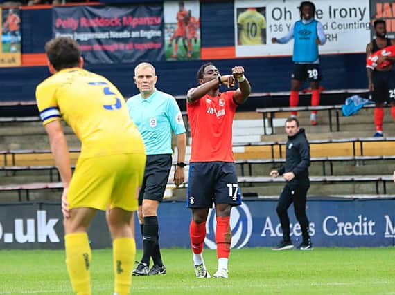 Pelly-Ruddock Mpanzu points to his wrist after curling him the opener against Wycombe on Saturday