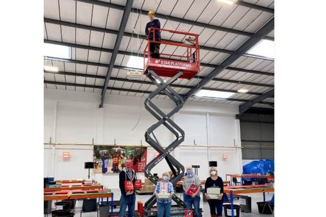Fitting ceiling heaters at Christmas shoebox charity warehouse (C) Esther Jolliffe (Jersey Road PR)
