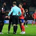 Referee Darren England discusses his decision with Alex Tettey and Jordan Clark