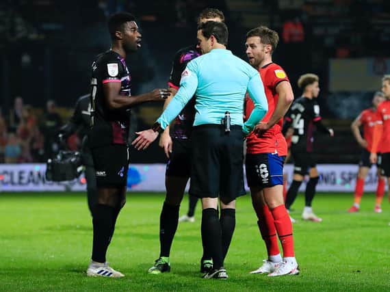 Referee Darren England discusses his decision with Alex Tettey and Jordan Clark