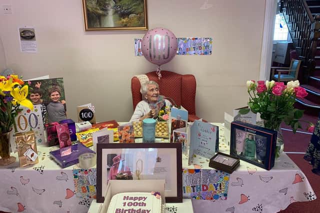 Louise on her birthday. Her grandsons can be seen on the big card to her left.