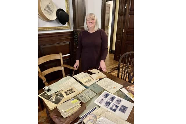 Linsey Betteridge with various documents relating to her family history