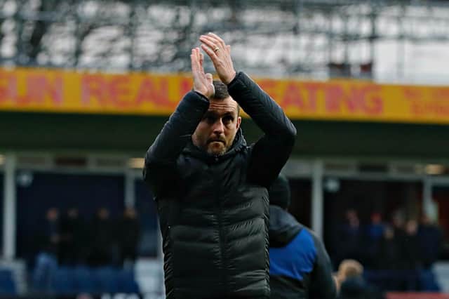 Town boss Nathan Jones applauds the home fans this afternoon