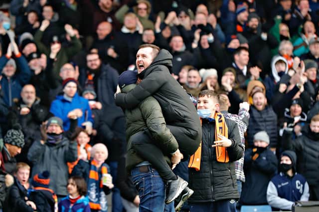 Luton boss Nathan Jones celebrates his side's win over Bournemouth with a Hatters supporter