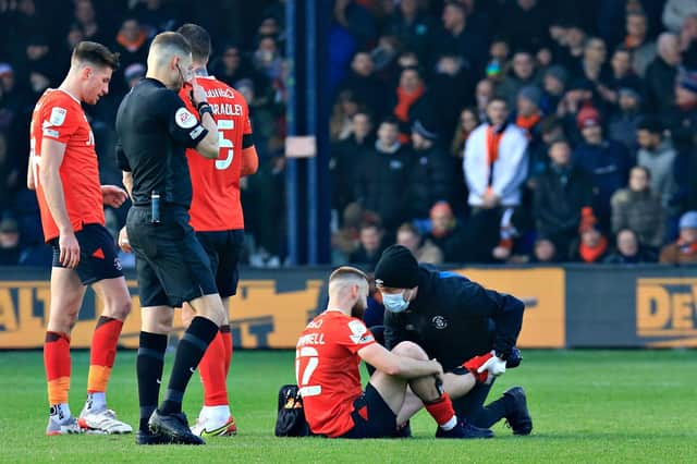 Town midfielder Allan Campbell receives treatment for his hamstring injury