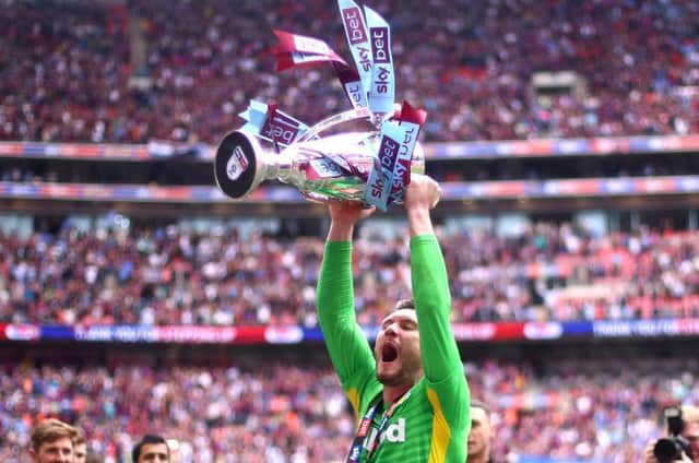 Jed Steer lifts the Championship play-off final trophy after helping Aston Villa beat Derby County in 2019
