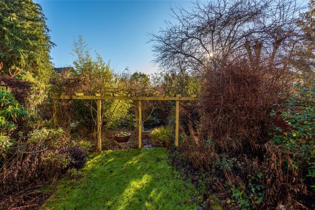 The southerly facing rear garden is fully enclosed and has a high level of screening. Steps lead down to a central lawn with well stocked borders and mature trees.