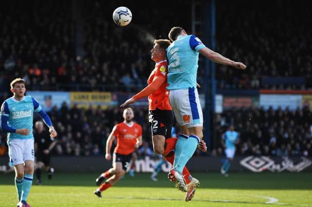 James Bree goes up for a header against Derby County