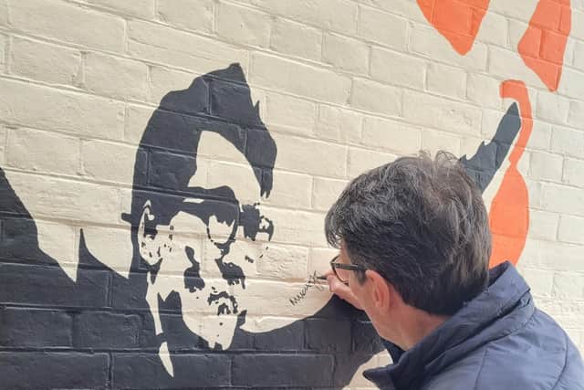 Mick signs the mural