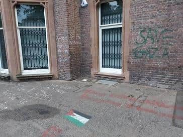 Slogans have been painted over the brick walls and pavement