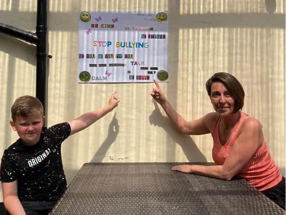 Alfie, 10, shows his poster with Brewery Tap landlady Gabrielle McKeown