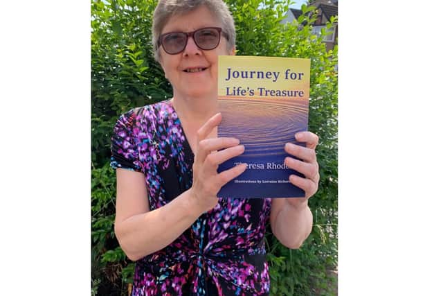 Theresa Rhodes with a copy of her recently published poetry anthology
