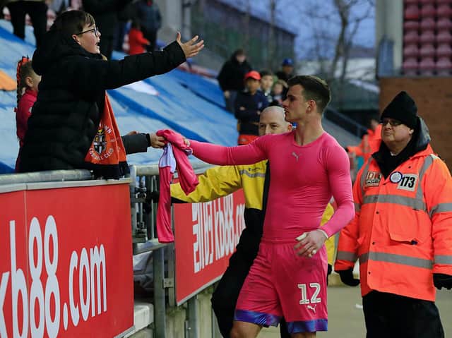 Simon Sluga gives his shirt to a Town supporter at Wigan in March 2020 - the last league game the Hatters fans were allowed to attend