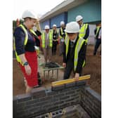 Executive Principal Louise Lee and student Jake Craythorne laying bricks.