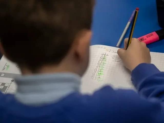 Child filling out work book. Picture: Danny Lawson via PA