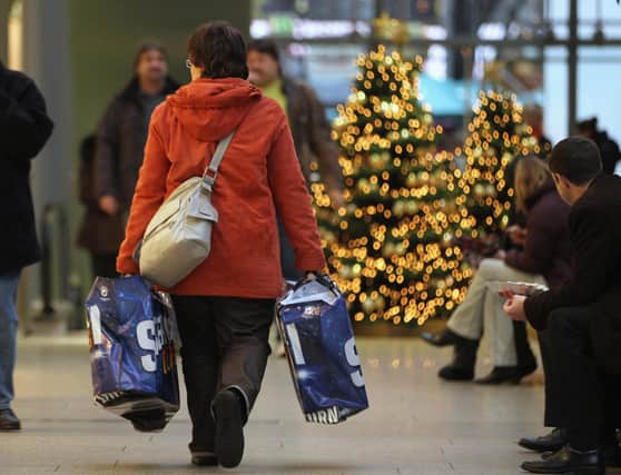 A woman carries shopping bags through a shopping mall on November 22, 2010 in Berlin, Germany. Photo by Sean Gallup/Getty Images)