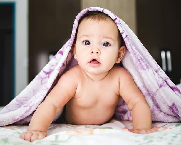 File picture of a baby under a blanket. Photo by Jonathan Borba on Unsplash