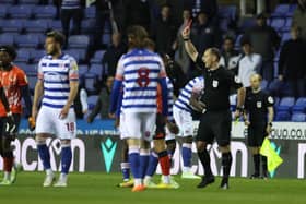Referee Tim Robinson brandishes a red card to Reading striker Andy Carroll