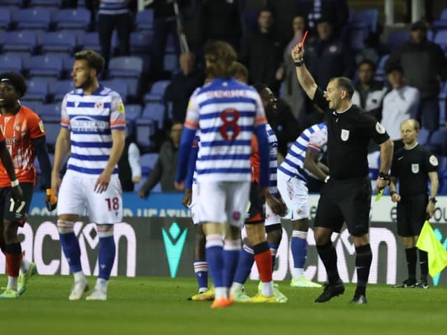 Referee Tim Robinson brandishes a red card to Reading striker Andy Carroll