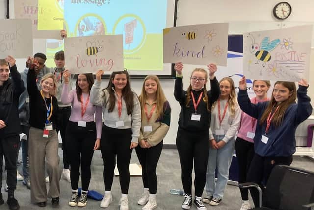 Young people hold up placards promoting mental health at the Future Leaders Conference organised by Co-operation Ireland
