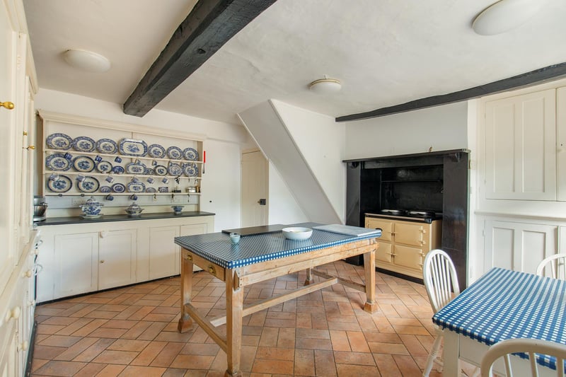 The traditional-style kitchen and breakfast room has tiled flooring, an electric Aga and a large utility room just to the side of it, with access to a private courtyard. Next door,  walk-in butlers pantry where you can take the stairs down to the cellars.