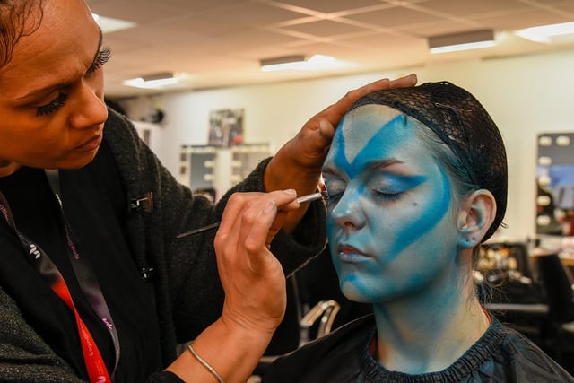 Fashion & media makeup student Cleo Young painting the face of her alien model, student Madison Smith