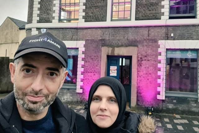 Yasmin and Khuram in front of the lit up Hat Works building
