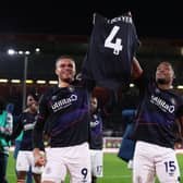 Carlton Morris and Teden Mengi hold Tom Lockyer's shirt aloft after a terrific 3-2 win at Sheffield United this afternoon - pic: George Wood/Getty Images