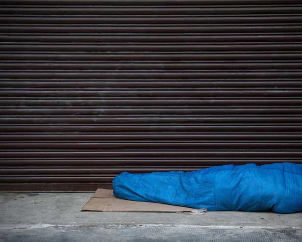 A homeless person sleeps in the entrance of a property. Photo by Carl Court/Getty Images