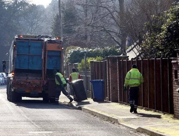 Refuse workers collect bins. Picture: Steve Parsons/PA