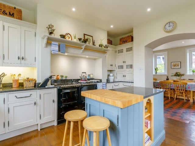 The kitchen has a large island with lots of storage, an AGA oven, and integrated appliances. It leads into the breakfast room, and has a pantry/utility room nearby.