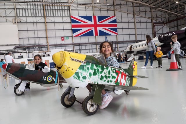 Aria and Maia Tailor on mini aircraft in the hangar