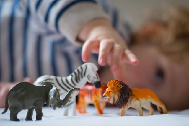 Preschool age child playing with plastic toy animals. Picture: Dominic Lipinski/PA Wire