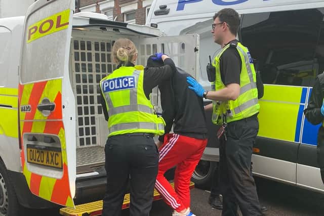 A suspect is put in a police van