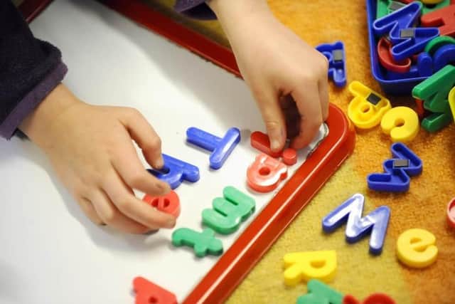 Children playing with letters. Picture: Dominic Lipinski/PA