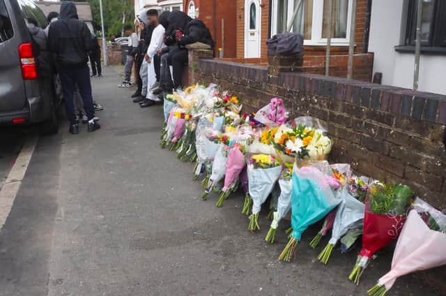 Floral tributes left at the scene my mourners. Picture: Tony Margiocchi