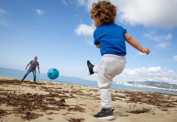 A child plays football with his father  in Palma de Mallorca. Photo by JAIME REINA/AFP via Getty Images