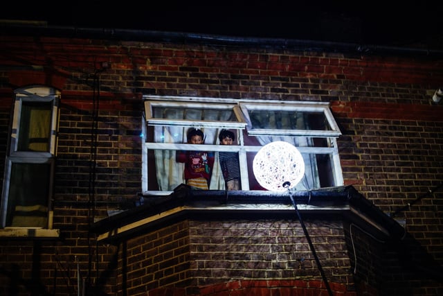 Children watch from a window