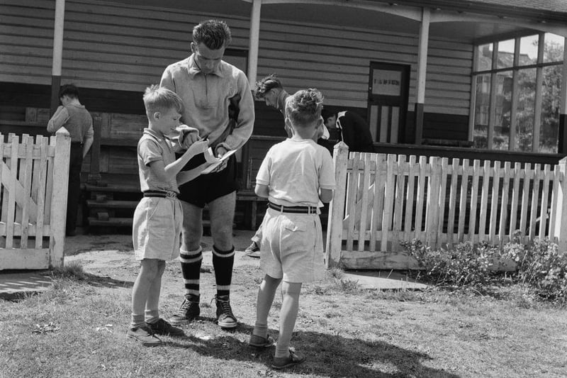 Luton defender Ken Hawkes signs autographs for young boys as he returns to the changing room following a training session ahead of the new season, in 1955. Luton had finished second the previous season which earned them promotion, playing in the First Division for the first time in the club's history.