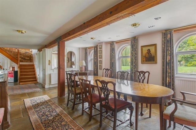 There are exposed beams in the dining room and throughout the rest of the house, along with stone floors.