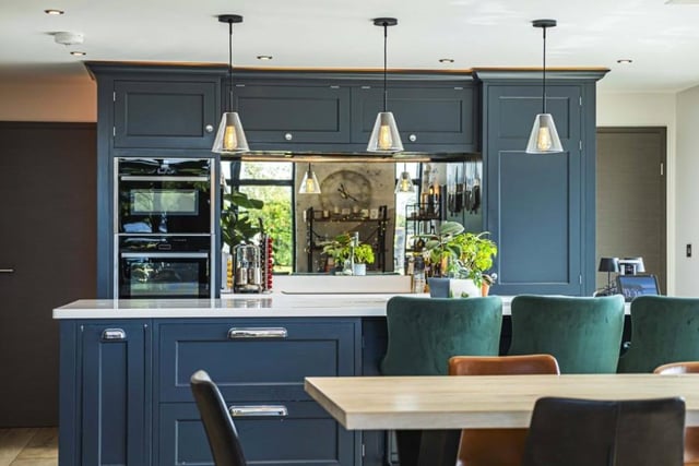 The kitchen has an island and a mirrored splashback