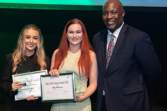 Phoebe Edwards (left) and Lucy Beaumont are presented with their award by ELFT Chief Operating Officer, Edwin Ndlovu.
