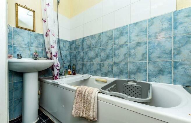 Despite its dated decor, the bathroom comes with a shower over the bath tub.